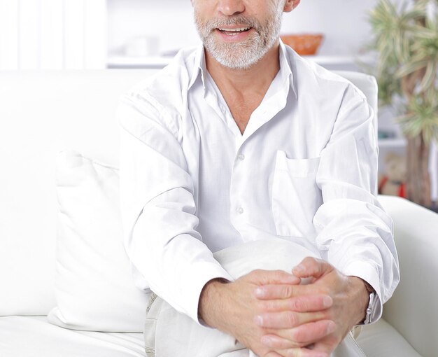 Serious businessman sitting on sofa in his office