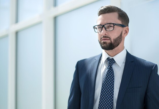 Serious businessman standing in a bright office