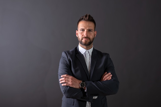 A serious businessman standing in a studio