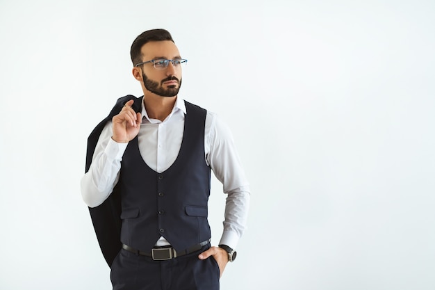 L'uomo d'affari serio in piedi sullo sfondo bianco