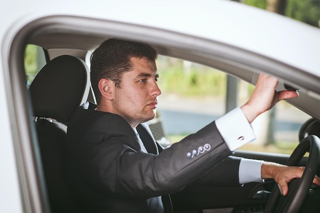 Serious businessman on steering the vehicle