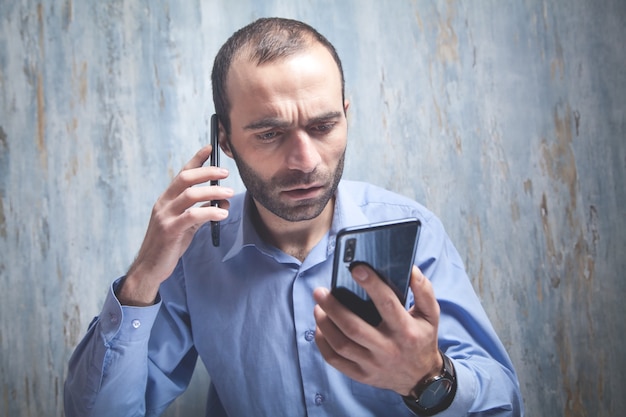 Foto imprenditore serio parlando sullo smartphone in ufficio.