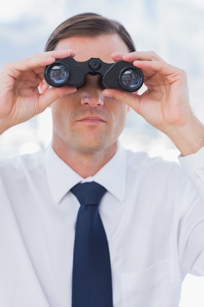 Serious businessman using binoculars