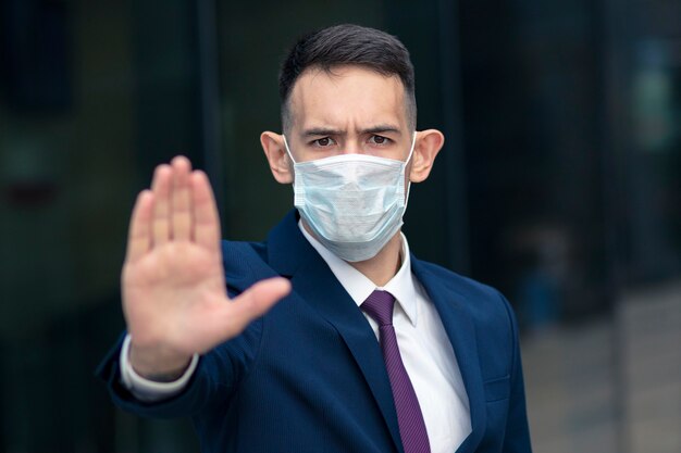 Serious businessman with medical mask on his face