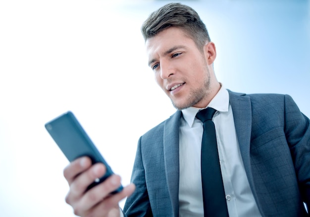 Serious businessman with phone reading message