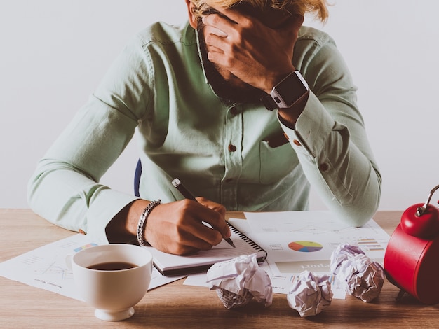 Uomo d'affari serio che lavora mentre sedendosi ad una coffice.