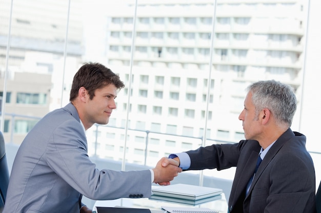 Serious businessmen shaking hands