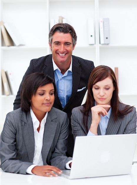 Serious businesswomen and their colleague working at a laptop