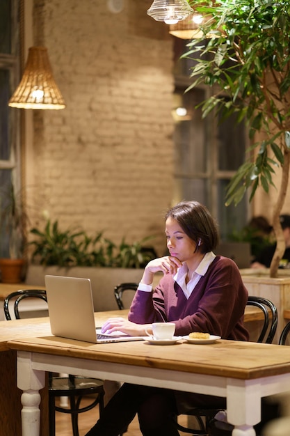 Serious busy afro female writer or journalist work in cafe use laptop and wifi internet connection