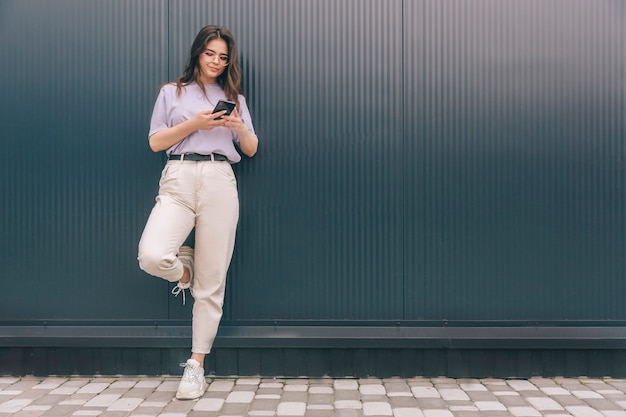 Photo serious busy woman looking through glasses on smartphone and using it