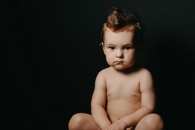 Serious child boy sitting on a pot