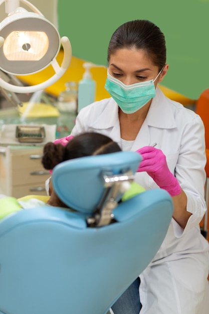 Serious concentrated female dentist performing a dental examination