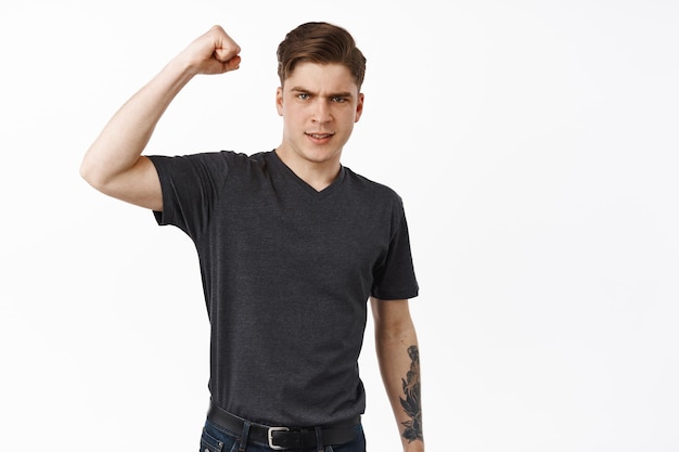 Serious and confident young man, activist and human rights suporter, raise fist and chanting, support something, fighting for freedom, lgbtq rights and equality concept