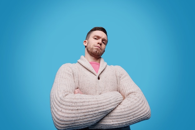 Serious and confident young man in casualwear crossing arms on chest while standing in isolation