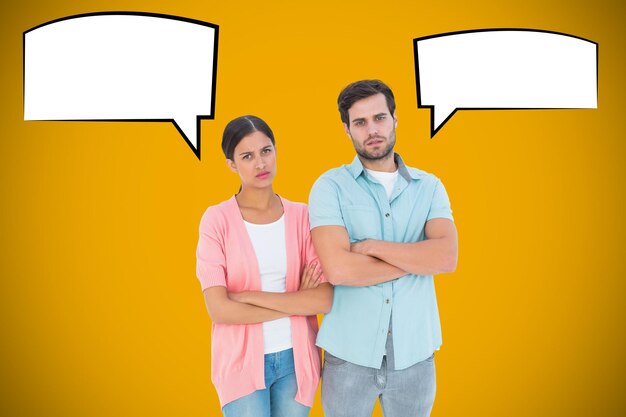 Serious couple with arms crossed against yellow background with vignette