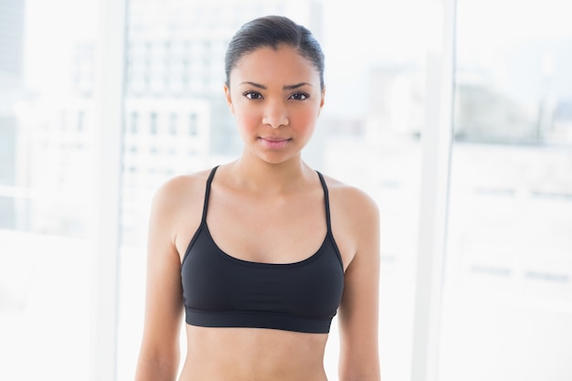 Photo serious dark haired model in sportswear posing looking at camera