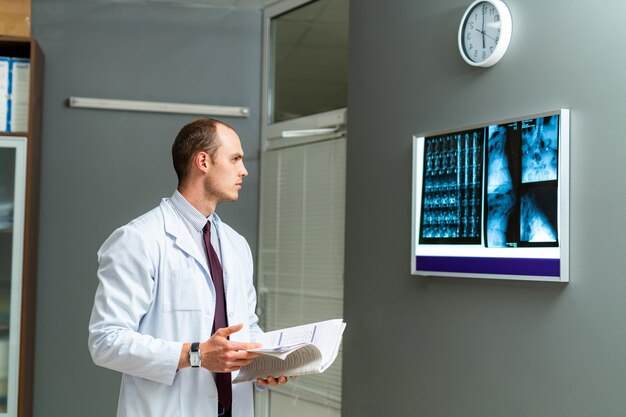 Photo serious doctor looking at the screen while working in modern clinic doctor is working in hospital experienced medic in clinic closeup