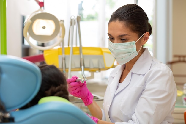 Serious doctor looking at a young female patient