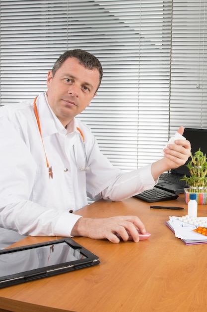 Serious doctor sitting at desk