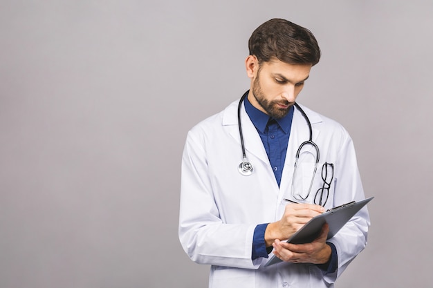 Serious doctor writing recipe on clipboard,