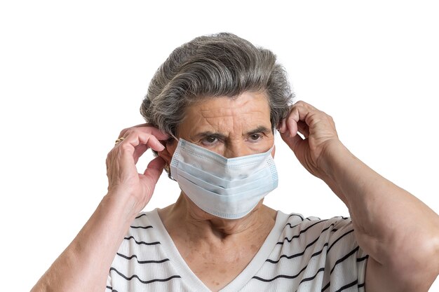 Serious elderly lady protecting with medical mask