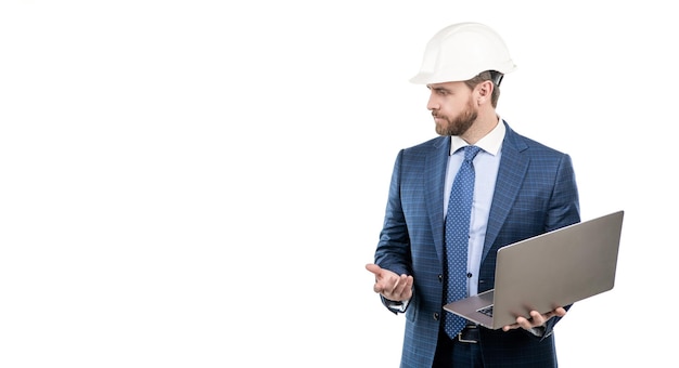 Serious engineer man in hardhat and suit use laptop computer for constructing engineering