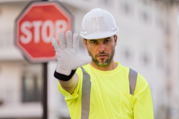 Foto ingegnere serio con costruttore di segnali stradali di stop con gesto di stop nessuna mano pericolosa sul concetto di costruzione