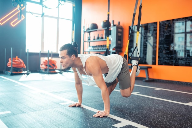 Serious fit man doing a special physical exercise