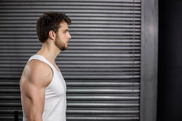 Serious fit man posing at gym