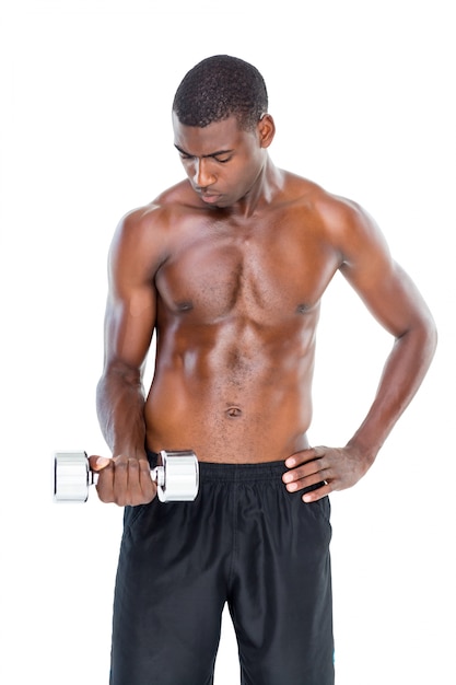 Serious fit shirtless young man lifting dumbbell