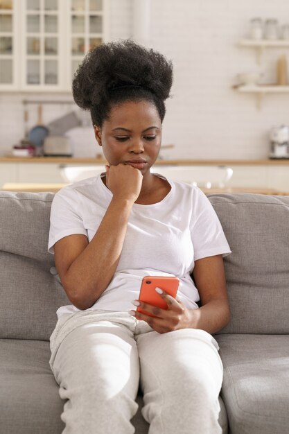 Serious focused black female read message on smartphone pensive girl get bad news in cell phone app