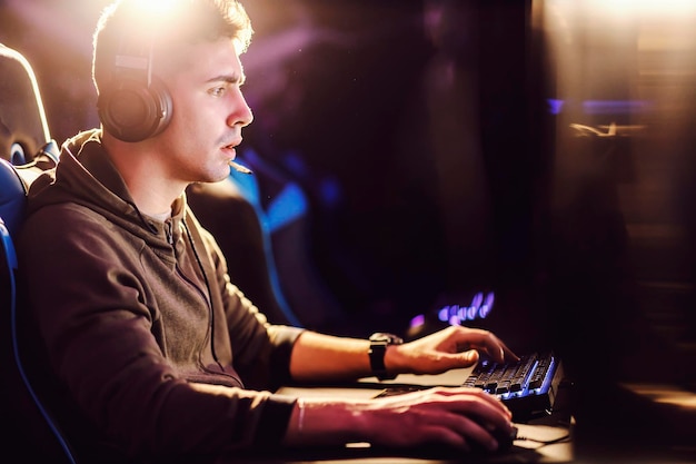 A serious gamer playing online video games at gaming room