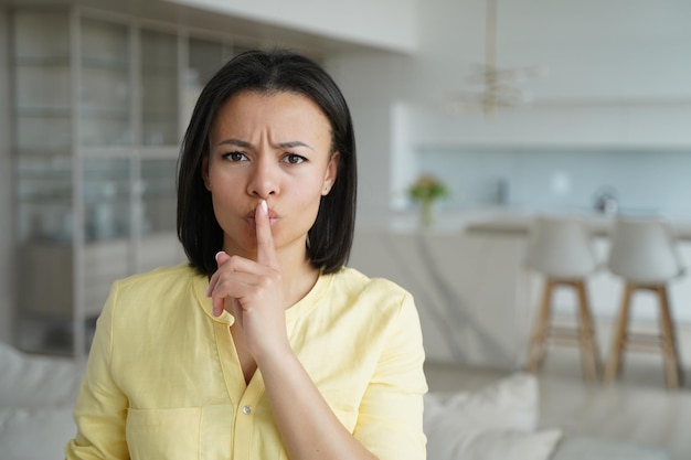 Serious girl gestures hush putting finger to her lips Advertising banner mockup with copy space