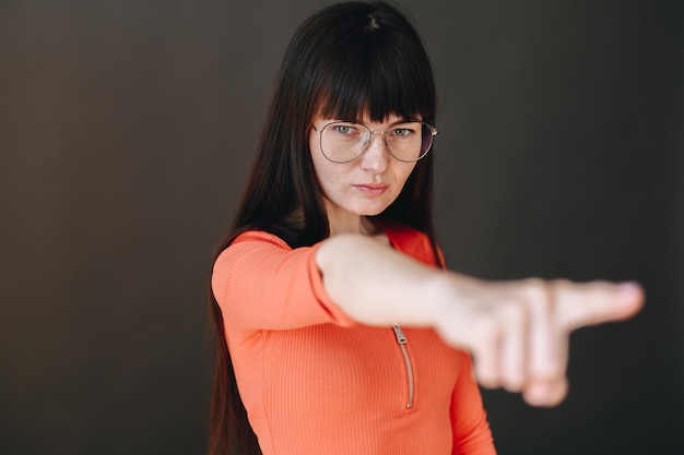 Serious girl in glasses shows thumbs up Angry girl