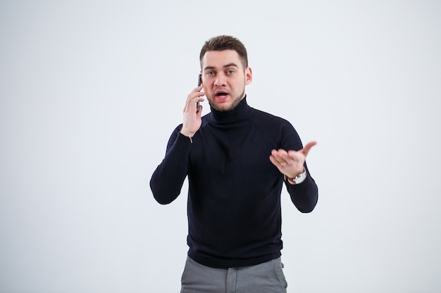 Un uomo d'affari serio in abiti neri scopre domande importanti per telefono. concetto di giornata lavorativa