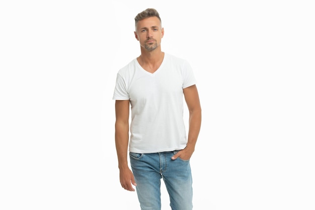 Serious handsome man in casual tshirt keep hand in pocket isolated on white, guy.