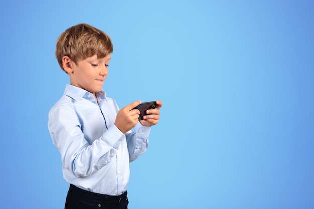 Serious little boy with smartphone blue