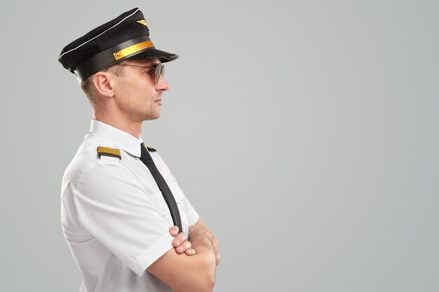 Serious male pilot in uniform in studio