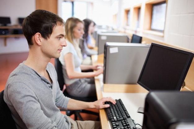 Serious male student working with a computer