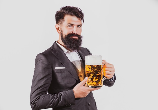 Uomo serio in abito classico che beve birra ragazzo barbuto in abito da lavoro sembra felice e soddisfatto p...