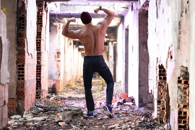 Serious Man Flexing Back Muscles in Ruins