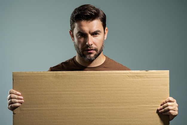 Photo serious man holding empty board successful man showing blank signboard with copyspace idea and offer