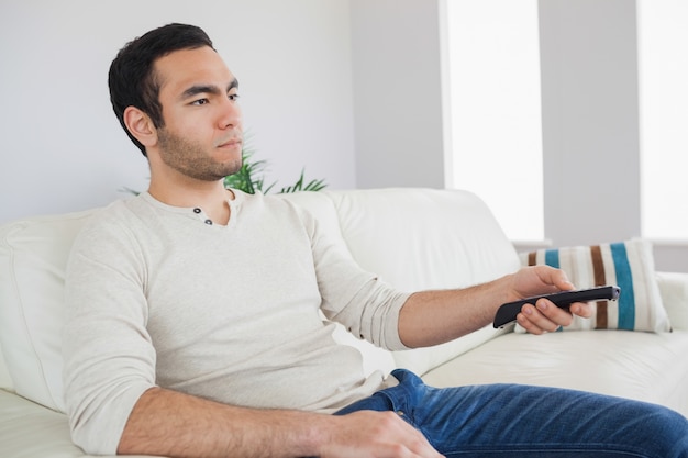 Serious man holding remote control