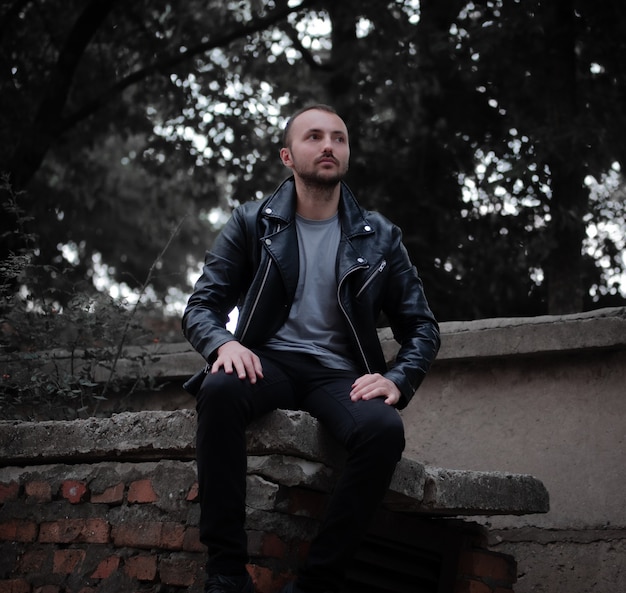 Serious man in leather jacket sitting