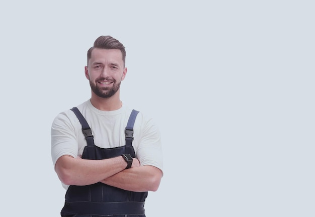 Serious man in overalls standing near the boxes isolated on whi