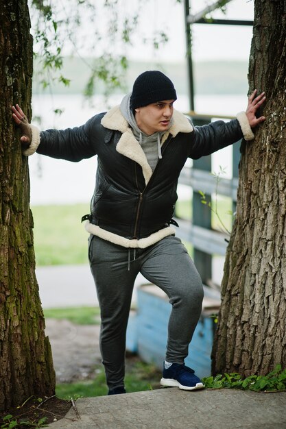 Serious man wearing leather jacket and black hat