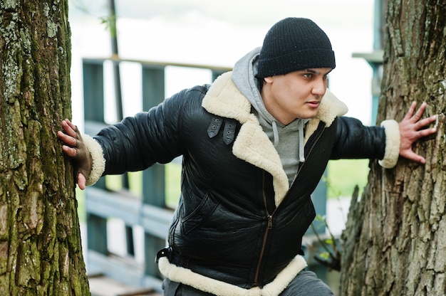 Serious man wearing leather jacket and black hat