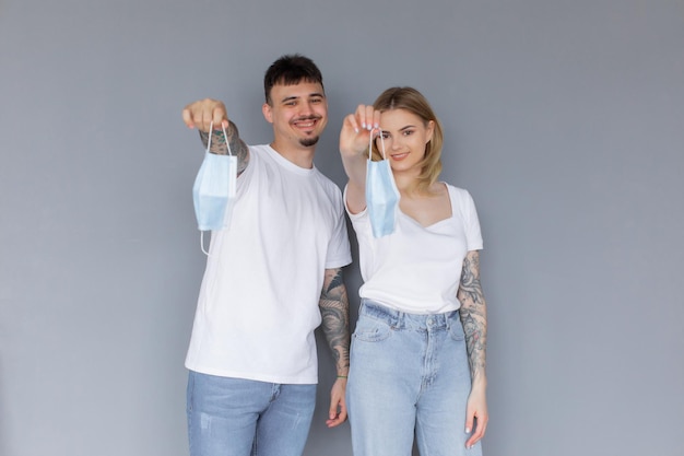 Serious man and woman with crossed hands standing back to back after quarrel wear medical mask