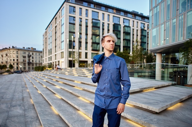 Serious manager in business suit stands near office center