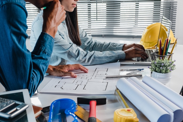 Foto l'uomo serio dell'ingegnere dell'architetto e la progettazione del womna seri che lavorano e che discutono i dati e lap